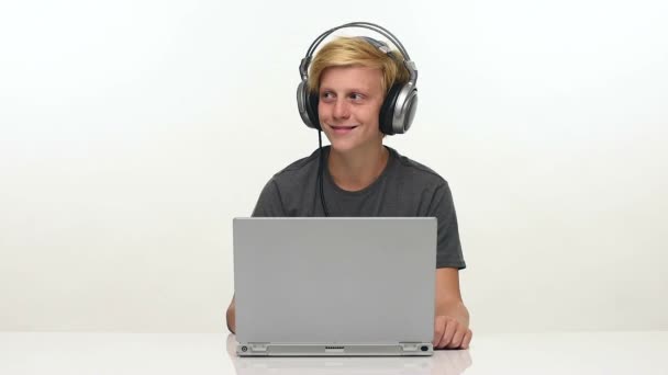 Teenager ascoltare musica sul suo computer portatile con le cuffie — Video Stock