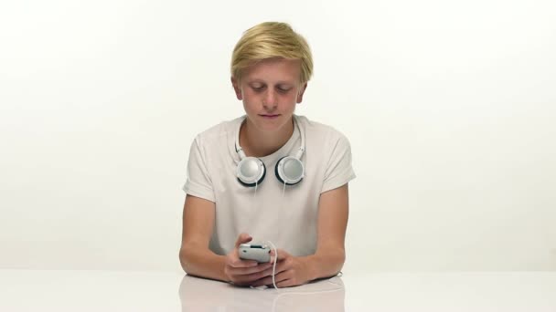 Teenager vyhledávání hudby na jeho smartphone — Stock video