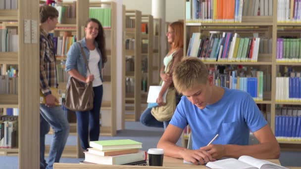 Étudiant sportif garçon apprentissage par bureau dans la bibliothèque de l'université 