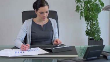 Ofisinde tablet ile gülümseyen iş kadını