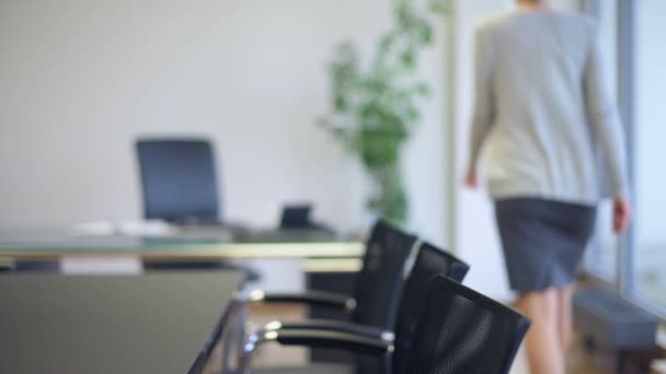 Mesa de oficina vacía con mujer de negocios caminando borrosa — Vídeos de Stock