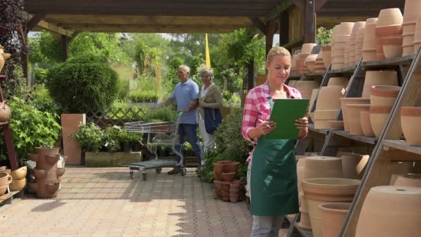 Empleado del centro de jardín trabajando con macetas — Vídeos de Stock