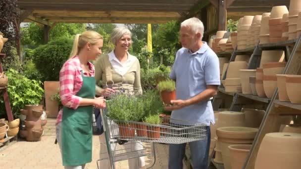 Garden center assistant helping customer couple — Stock Video