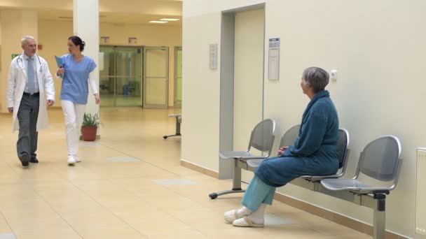 Nurse talking with patient in hospital corridor — Stock Video