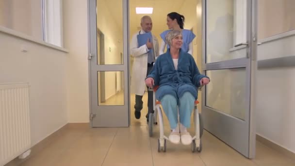 Médecin et infirmière marchant avec le patient en fauteuil roulant — Video