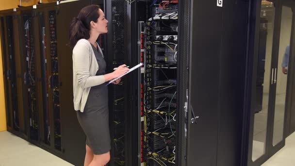 Vrouwelijke netwerk technicus in datacenter — Stockvideo