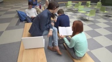 Üniversite öğrencileri okul binası içinde merdivenlerde öğrenme