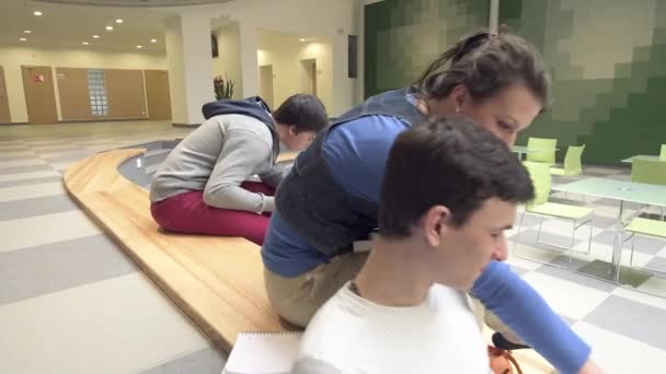 Grupo de adolescentes en el salón universitario estudiando — Vídeo de stock