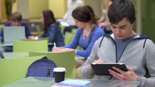 Tinédzser fiú gépelés a modern iskola teremben tabletta — Stock videók