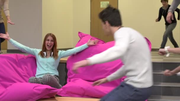 Gruppo di studenti saltare su beanbag al college — Video Stock