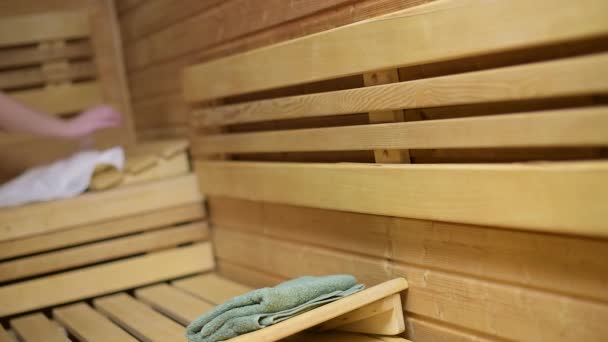 Femme couchée sur un banc de sauna — Video