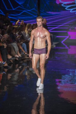 Sanat, Kalpler, Moda Yüzme Haftası sırasında Miami Plajı 'ndaki Faena Forum' da Bay Üçlü X Moda Şovu için podyumda bir manken yürüyor.