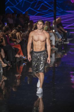 Sanat, Kalpler, Moda Yüzme Haftası sırasında Miami Plajı 'ndaki Faena Forum' da Bay Üçlü X Moda Şovu için podyumda bir manken yürüyor.
