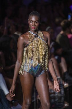 Sanat, Kalpler, Moda Yüzme Haftası sırasında Miami Plajı 'ndaki Faena Forum' da Bay Üçlü X Moda Şovu için podyumda bir manken yürüyor.