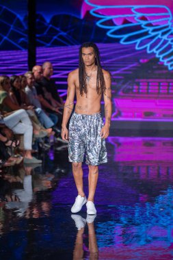 Sanat, Kalpler, Moda Yüzme Haftası sırasında Miami Plajı 'ndaki Faena Forum' da Bay Üçlü X Moda Şovu için podyumda bir manken yürüyor.