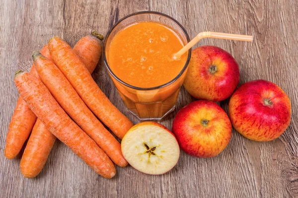 Blended orange smoothie with ingredients on wooden table — Stock Photo, Image