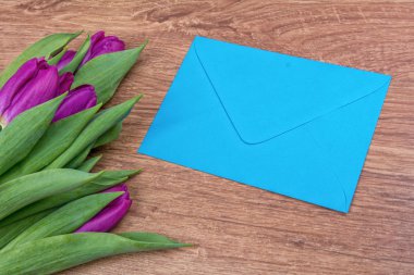 Zarf ile ahşap arka plan üzerinde mor laleler