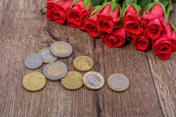 Euro sikke ve gül ahşap arka plan üzerinde