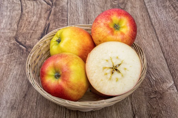Pommes dans un bol tricoté sur un fond en bois — Photo