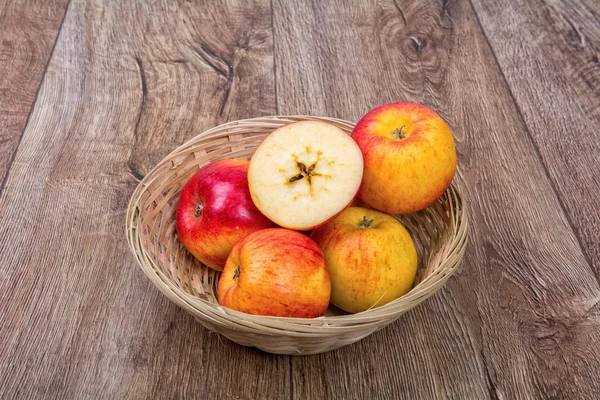 Pommes dans un bol tricoté sur un fond en bois — Photo