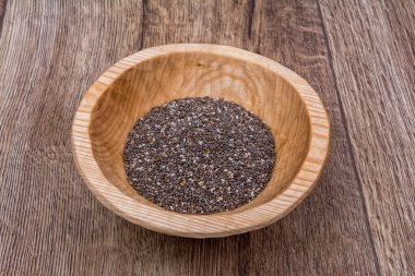 Ahşap bir arka plan üzerinde ahşap bir kase chia tohumları