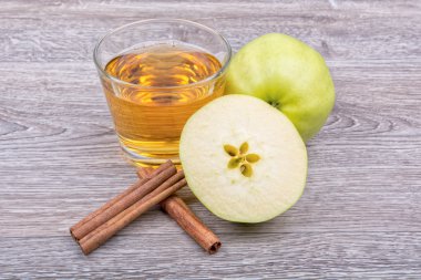 Elma, tarçın ve meyve suyu ahşap bir arka plan üzerinde
