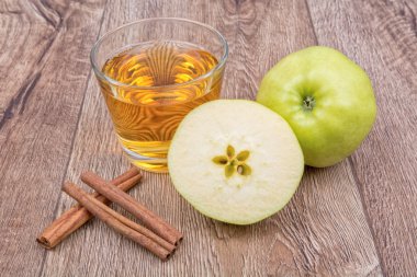 Elma, tarçın ve meyve suyu ahşap bir arka plan üzerinde