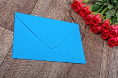 Mavi bir zarf içerisinde ve gül ahşap arka plan üzerinde