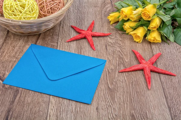 Briefumschlag, Seesterne und Rosen auf einem hölzernen Hintergrund — Stockfoto