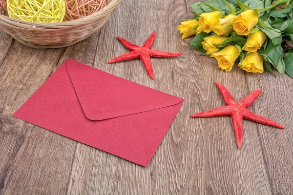 Briefumschlag, Seesterne und Rosen auf einem hölzernen Hintergrund — Stockfoto