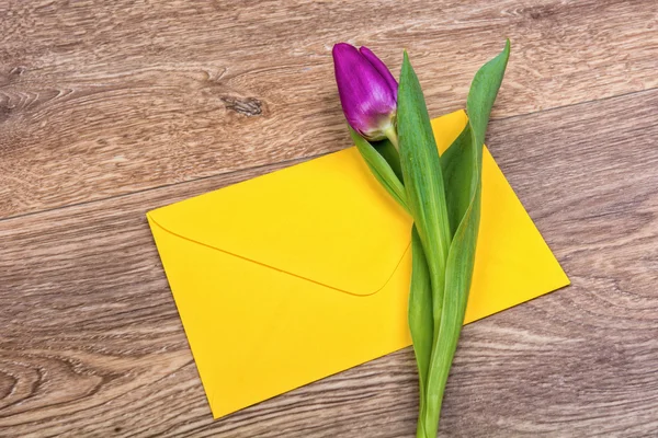 Kuvert och tulip på trä bakgrund — Stockfoto