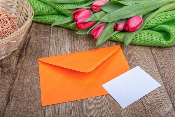 Kuvertet med pappersark och tulpaner på trä bakgrund — Stockfoto