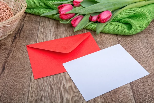 Kuvertet med pappersark och tulpaner på trä bakgrund — Stockfoto