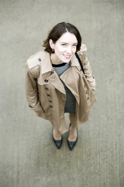 Woman at beige coat and gray square concrete — Stock Photo, Image