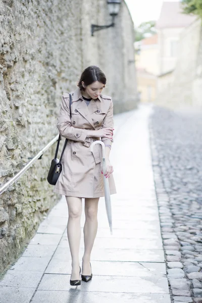 Vrouw op beige jas bleke hand kijken — Stockfoto