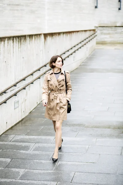 Woman at coat coming down hurriedly by downhill — Stock Photo, Image