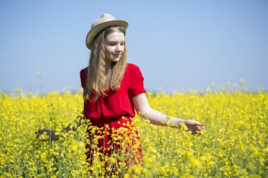 Sarı bitkiler arasında Kırmızı elbiseli kadına