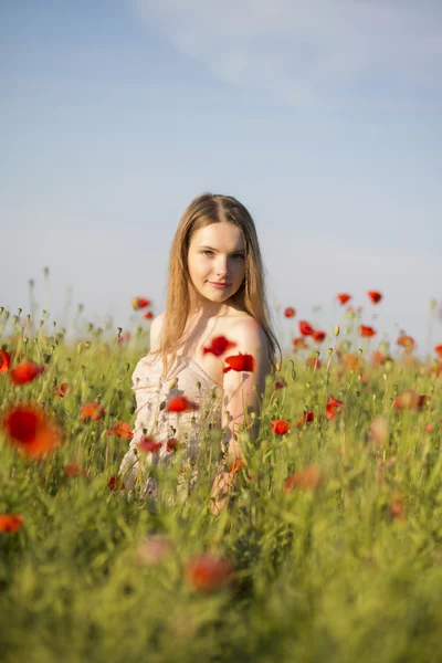 Frau im Kleid posiert auf Mohnfeld — Stockfoto