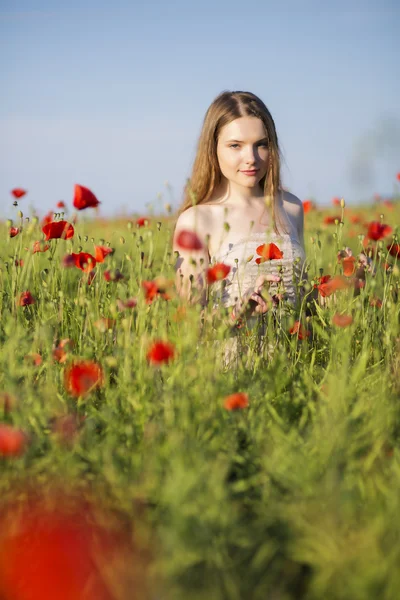 Mujer en vestido blanco en el campo de amapolas —  Fotos de Stock