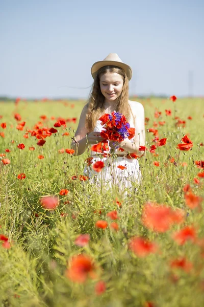 Vrouw aan het witte jurk aanpassen poppy boeket — Stockfoto