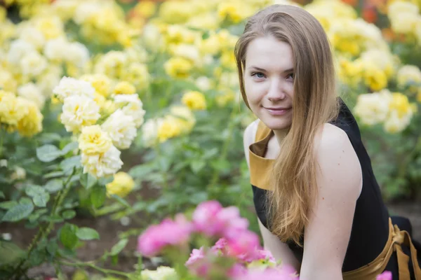 Vrouw alleen en vele gele rozen rond — Stockfoto