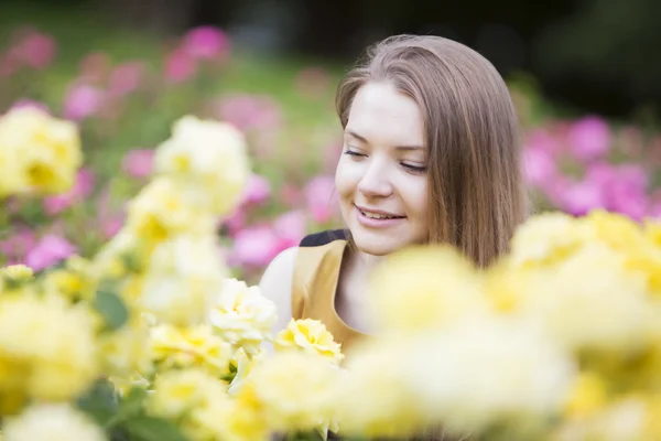 Donna felice circondata da molte rose gialle — Foto Stock