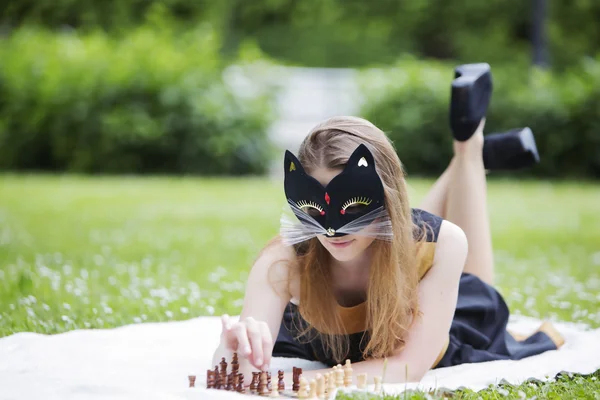 Frau mit Maske passen hölzerne Schachfiguren an — Stockfoto