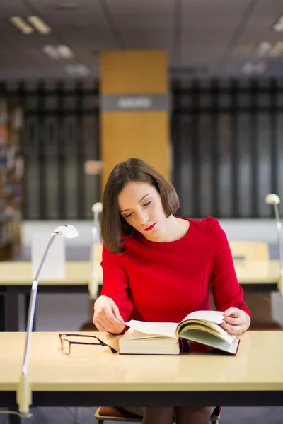 Mulher na biblioteca ler livro para a razão — Fotografia de Stock
