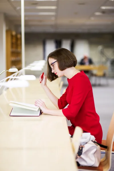 Mulher com óculos na biblioteca fazer comentários — Fotografia de Stock