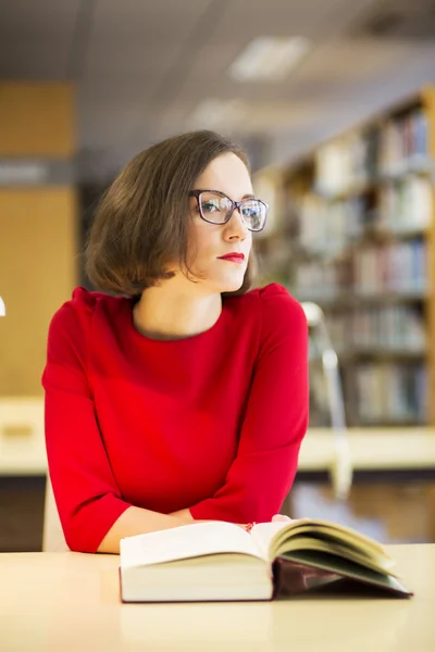 Mulher com óculos na biblioteca olhar ao redor — Fotografia de Stock