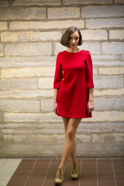 Woman in hallway on brick wall background — Stock Photo, Image