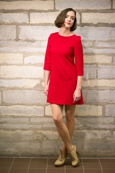 Woman in hallway posing on limestone wall — Stock Photo, Image