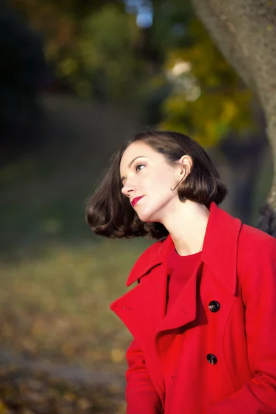 Frau im Herbstpark genießt sonnigen Tag — Stockfoto