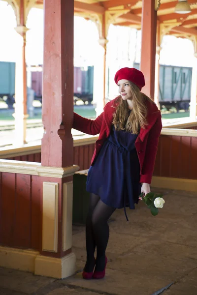 Femme à la gare avec rose à portée de main — Photo